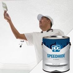 a man holding a paint can and painting the ceiling with it's white primer