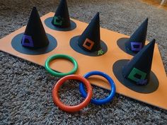 four black witches hats sitting on top of a wooden board next to o - rings