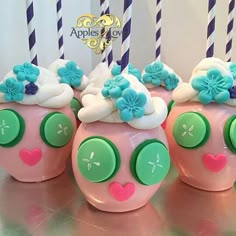 there are four pink and green cupcakes with flowers on them