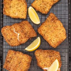 chicken schnitz on a grill with lemons and parmesan cheese for garnish