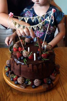 Berry Chocolate Birthday Cake - Three layer chocolate cake filled with chocolate mousse and frosted with chocolate buttercream frosting and dripping dark chocolate ganache, then topped with strawberries, blueberries, ferrero rocher candy and various chocolate bars.  (Plus some rosemary leaves as garnish) Rustic Chocolate Cake Birthday, Chocolate Fruit Cake Birthday, Cake With Ferrero Rocher On Top, Chocolate 30th Birthday Cake, Chocolate Cake With Berries On Top, Dark Chocolate Birthday Cake, Chocolate Birthday Cake With Flowers, Dark Chocolate Cake Decoration, Decorate Chocolate Cake Ideas