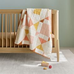 a baby crib with a blanket on top of it next to a toy roller