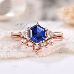 an engagement ring with a blue stone surrounded by white and rose gold diamonds on top