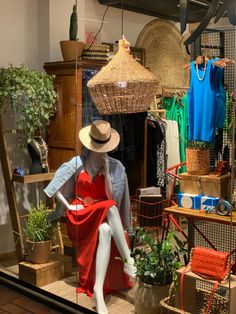 a store window with mannequins and hats on display