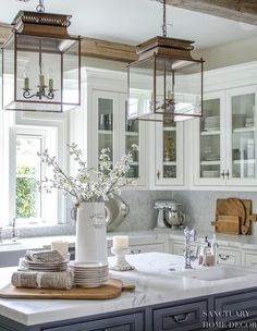 a kitchen with white cabinets and lots of counter space, including a center island in the middle