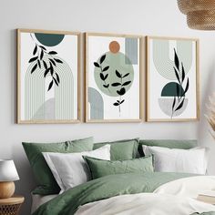 two framed art prints on the wall above a bed with green sheets and white pillows