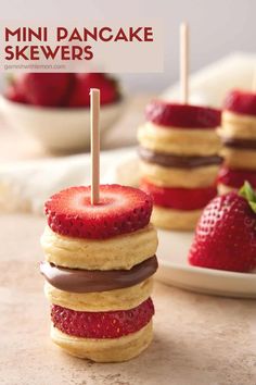 strawberry shortcakes stacked on top of each other with strawberries in the background