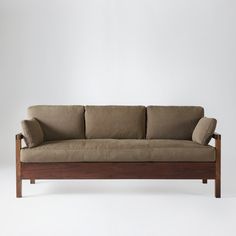 a brown couch sitting on top of a wooden frame