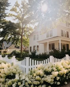 a white picket fence in front of a large house