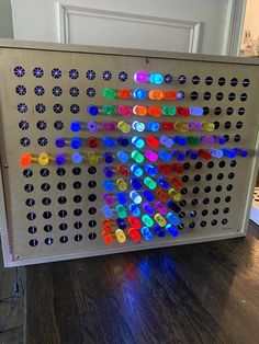 an array of colored buttons is displayed on a large metal screen in front of a door