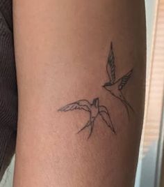 a small bird tattoo on the arm