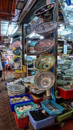 an outdoor market with lots of bowls and plates