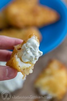 a hand holding up a pastry with cream cheese on it