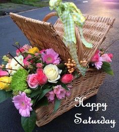 a basket filled with flowers sitting on the side of a road