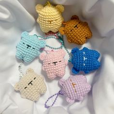 four crocheted key chains with small teddy bears on them, all in different colors