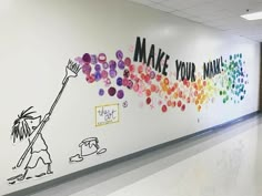 an office hallway decorated with colorful paper flowers and writing on the wall that says make your own