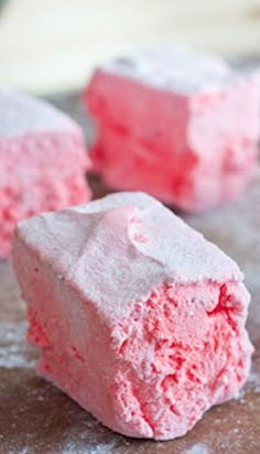 three pieces of pink cake sitting on top of a table