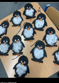 a bunch of penguins that are sitting on a wooden table with string attached to them