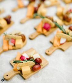 small wooden trays filled with different types of cheese and fruit on top of a table