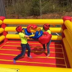 two children playing in an inflatable boxing ring