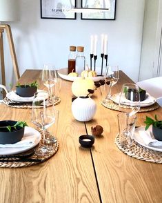 a wooden table topped with plates and glasses