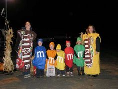 a group of people in costumes standing next to each other on a road at night