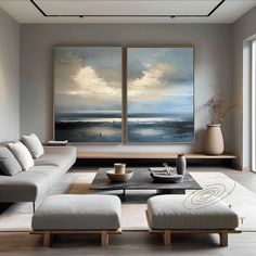 a living room with two paintings on the wall and a coffee table in front of it