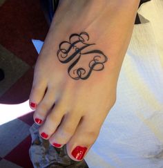 a woman's foot with a monogrammed tattoo on it