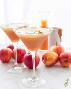 two martini glasses filled with apple cider