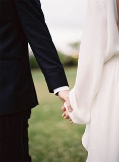 a close up of two people holding hands