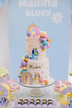 there is a white cake with rainbow decorations on it