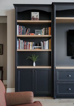 a living room filled with furniture and a flat screen tv on top of a wooden shelf