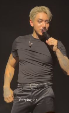 a man with blonde hair is holding a microphone