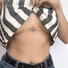 a woman's stomach with a lotus tattoo on her lower back and the bottom part of her abdomen