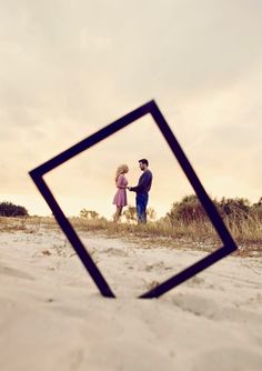 an image of a man and woman holding hands on the beach