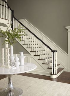 there is a vase with flowers on the table in front of the stair railings