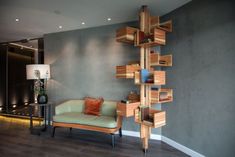 a living room filled with furniture and a tall wooden book shelf next to a lamp