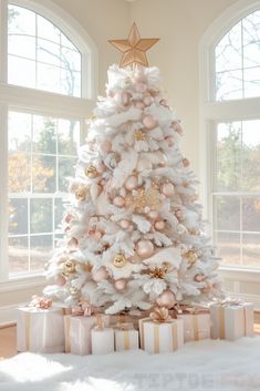 a white christmas tree with pink and gold ornaments