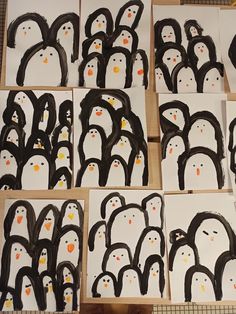 penguins are painted on white paper with black and orange dots