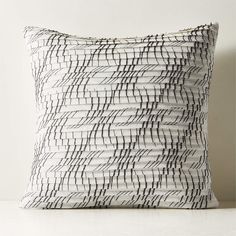 a black and white pillow sitting on top of a table