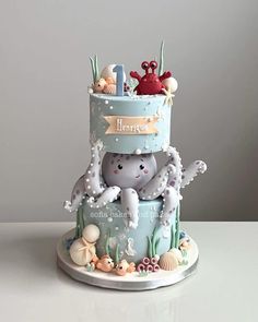 there is a cake that has an octopus on it and sea animals in the bottom tier