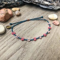 "Introducing my first \"Little Flower\" design! This color palette was inspired by blossoming trees. We see a lot of pinks on the trees around us in the spring, the sweet smells and soft petals on the ground that my kids will inevitably pick up. Happy colors!  This bracelet matches perfectly with the seed bead version, found here: https://colorsoftheprairie.etsy.com/listing/1451854024 Please keep in mind that even though I try my best to keep the spacing even between flowers, I'm not a machine and the spaces are not all perfectly equal. I think this adds to unique-ness and similarity to wild flowers in nature! They don't grow in straight lines! But if you are unhappy, please let me know ASAP and see my \"Happiness Guarantee\" down below. This listing is for 1 adjustable seed bead bracelet Pink Bohemian Beaded Bracelets With Adjustable Cord, Bohemian Pink Beaded Bracelets With Adjustable Cord, Pink Beaded Bracelets For Spring Festival, Adjustable Beaded Bracelets For Spring Festival, Spring Festival Pink Beaded Bracelets, Casual Pink Beaded Bracelets With Adjustable Cord, Bohemian Beaded Bracelets For Friendship In Spring, Bohemian Beaded Bracelets For Friendship And Spring, Spring Bohemian Adjustable Beaded Bracelets