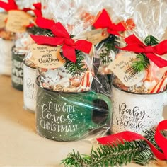 three mugs filled with christmas treats on top of a table