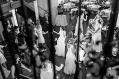 a group of people that are standing in the middle of a room with tables and chairs