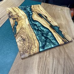 a piece of wood that is sitting on top of a table with blue and green paint