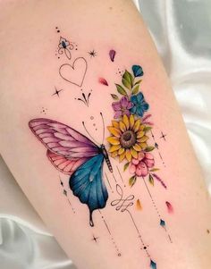 a colorful butterfly and flower tattoo on the thigh