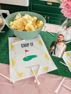 a bowl of chips sitting on top of a table next to a card with the word chip it