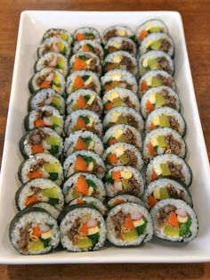 a white plate topped with lots of sushi