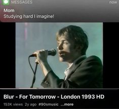 a man holding a microphone in front of a screen with the words blur for tomorrow on it