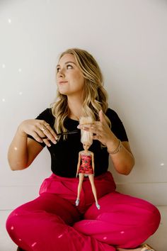 a woman sitting on the floor holding a doll